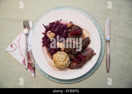 Le dîner de Noël en Autriche, la venaison typiques de saison plat à décor de filet avec du chou rouge et marrons, pain dumpling et sauce aux canneberges. Banque D'Images