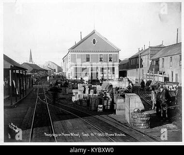 Une photographie prise le 19 septembre 1905, montrant le quai de Nome en Alaska avec le bâtiment de l'Alaska Mercantile Company, illustrant l'activité commerciale côtière du début du XXe siècle. Banque D'Images