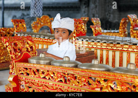 Jeune garçon, environ 5 ans, colle pour temple avec instruments de gamelan, Lovina, Bali, Indonésie. Banque D'Images