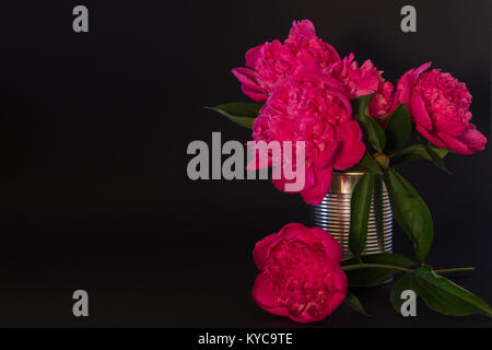 Bouquet de pivoines rose dans un vase d'étain sur fond noir Banque D'Images