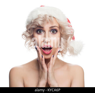 Femme de Noël à Santa Hat isolé sur fond blanc . Mignon surpris Femme avec bouche ouverte. Concept de Noël Banque D'Images