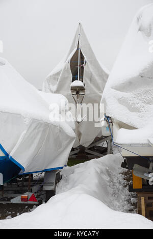 Les bateaux de plaisance enregistrés sur la terre ferme dans une marina en hiver en Norvège. Banque D'Images