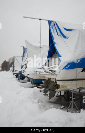 Les bateaux de plaisance enregistrés sur la terre ferme dans une marina en hiver en Norvège. Banque D'Images