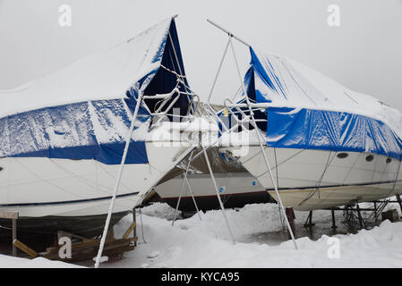 Les bateaux de plaisance enregistrés sur la terre ferme dans une marina en hiver en Norvège. Banque D'Images