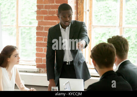 Rude impoli african businessman pointing finger au collègue de réunion d'équipe, d'angry black boss réprimandes employé blanc pour mauvais travail, multiracial con Banque D'Images