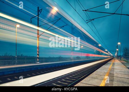 Sentier de lumière le train express dans la gare à la nuit. Banque D'Images