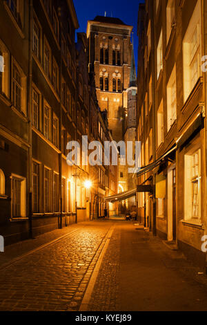 Dans la vieille ville de Gdansk en Pologne, la nuit rue Kramarska avec St Mary Church à la fin. Banque D'Images