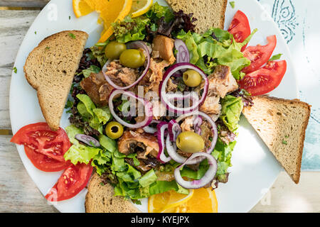 Avec une salade de poissons Poissons carpe, les olives, l'oignon, salade verte et du pain Banque D'Images