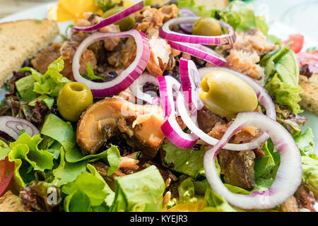 Avec une salade de poissons Poissons carpe, les olives, l'oignon, salade verte et du pain Banque D'Images