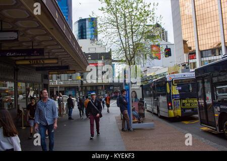 Les gens et les autobus de transport en commun sont visibles à l'extérieur des magasins de détail sur Queen Street, une rue commerçante populaire à Auckland, Nouvelle-Zélande, le 10 octobre 2017. () Banque D'Images