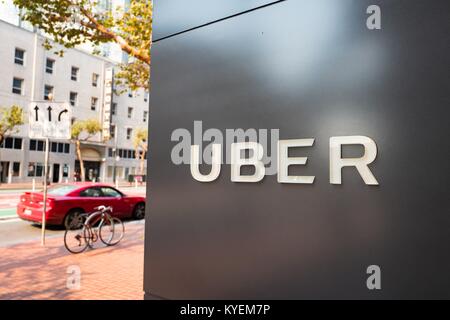 Signer avec logo au siège de l'entreprise de technologie de l'auto-partage dans l'Uber South of Market (SoMa) quartier de San Francisco, Californie, avec véhicule rouge visible à l'arrière-plan en stationnement sur Market Street, le 13 octobre 2017. SoMa est connu pour avoir la plus forte concentration d'entreprises technologiques et d'entreprises d'une région à l'échelle mondiale. () Banque D'Images