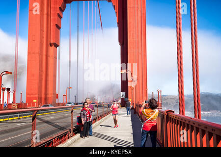SAN FRANCISCO, CA- 11 Octobre 2015 : Sur le Golden Gate Bridge sur une journée ensoleillée avec du brouillard à l'arrière-plan. Les gens dans la zone piétonne de voie sont indiqués en tenant Banque D'Images