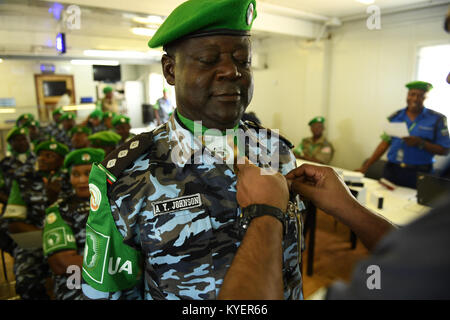 Anand Pillay, le commissaire de police de la Mission de l'Union africaine en Somalie (AMISOM), les axes d'une médaille sur un uniforme d'agent de police au cours d'une cérémonie de remise des médailles pour souligner le départ d'un contingent d'agents de police du Nigeria à l'administration centrale de l'AMISOM à Mogadiscio, en Somalie, le 8 septembre 2017. L'AMISOM Photo / Omar Abdisalan Banque D'Images