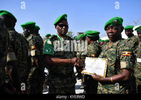 Le Major-général Salvatore Harushimana, le commandant adjoint de la Force de la Mission de l'Union africaine en Somalie (AMISOM), les mains sur un certificat d'un officier militaire de l'AMISOM au cours d'une cérémonie de remise des médailles, à Mogadiscio, le 30 novembre 2017. L'AMISOM Photo / Omar Abdisalan Banque D'Images