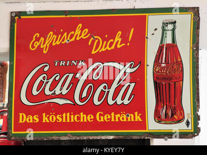 Photographie d'une enseigne publicitaire vintage en émail Coca-Cola exposée au Fahrzeugmuseum Marxzell, mettant en valeur le design historique et l'image de marque de la populaire entreprise de boissons. Banque D'Images