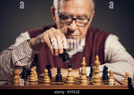 Portrait of senior homme qui participe au jeu d'échecs. Banque D'Images