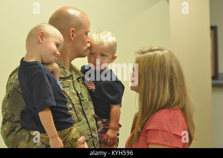 Le capitaine de la 613e Vance Tchad Installations Ingénieur embrasse son détachement fils Gage comme épouse Krissy et fils Gavin regarde. L'unité a quitté Springfield, Ky pour l'Afghanistan le 20 juin 2012 à l'appui de l'opération Enduring Freedom. Banque D'Images