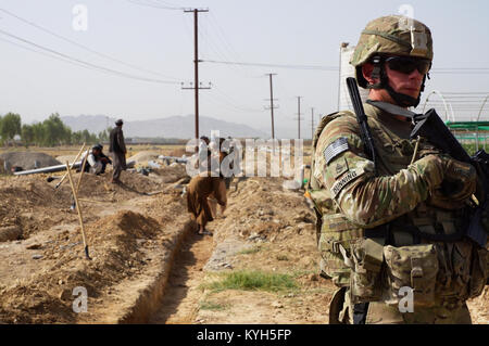 L'équipe de développement de l'Agribusiness : Kentucky 4 Sgt. 1re classe Greg Dunning de Almo, Ky. signifie regarder comme des Afghans de creuser un fossé de l'irrigation dans le sud de l'Afghanistan le 11 juillet 2012. Les températures à trois chiffres au cours de l'été et un climat sec faire bonne irrigation un aspect essentiel de la culture dans la région. Aux États-Unis (photo par le Sgt. Paul Evans) Banque D'Images