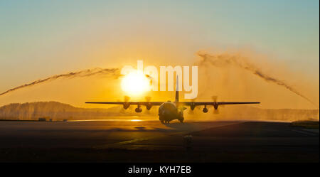 Les camions incendie pulvériser de l'eau dans un geste symbolique salut à un C-130 Hercules qu'il circule sur la ligne de vol de la base de la Garde nationale aérienne du Kentucky à Louisville, Ky., le 10 novembre 2012, portant 58 gardes de l'air du Kentucky de retour de la guerre du Golfe. Les Aviateurs, tous les membres de la 123e base Louisville-Airlift Wing, passé les quatre mois les missions de transport aérien du vol à l'appui des opérations militaires des États-Unis dans la zone de responsabilité, qui inclut l'Irak, l'Afghanistan et l'Afrique du Nord. (U.S. Photo de l'Armée de l'air par le Major Dale Greer) Banque D'Images