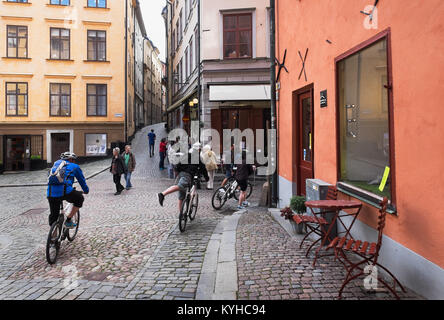 Stockholm, Suède groupe guidé tour à vélo dans les étroites rues pavées de la ville pittoresque de la vieille ville Gamla Stan, ou vieille ville. Banque D'Images