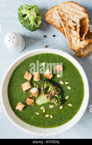 Crème de brocoli soupe avec des croûtons, de l'huile d'olive et les pignons de pin dans un bol. Vue de dessus, gros plan. La nourriture végétarienne saine Banque D'Images