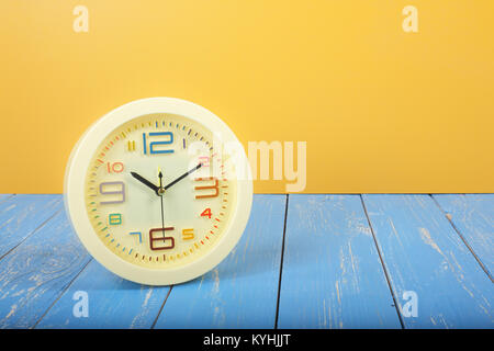 Vintage Réveil - Ancienne rétro réveil sur une planche en bois et bleu sur fond jaune. Banque D'Images