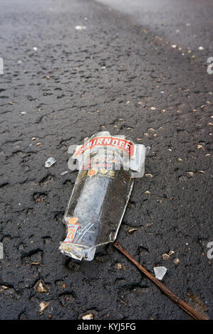 Tesson de bouteille de vodka Smirnoff sur le trottoir. Banque D'Images