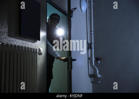 Recherche Agent de sécurité mâle avec torche à Industrie Banque D'Images