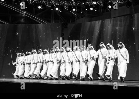 Dubaï, Émirats arabes unis - Dec 3, 2017 : un groupe d'hommes habillés de façon traditionnelle (danse d'ayala stick dance) qui fait partie intégrante de la communauté du patrimoine. Banque D'Images