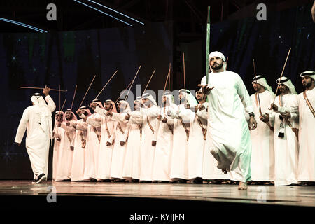 Dubaï, Émirats arabes unis - Dec 3, 2017 : un groupe d'hommes habillés de façon traditionnelle (danse d'ayala stick dance) qui fait partie intégrante de la communauté du patrimoine. Banque D'Images