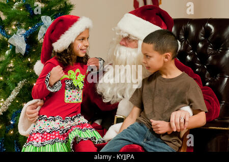 La fille et le fils de l'Aviateur Senior Jose Lopez Castro, chef d'équipe pour le 123e Escadron de maintenance des aéronefs, de parler avec le Père Noël au cours de la 123e Airlift Wing's family holiday party au Texas Air National Guard Base à Louisville, Ky., 2 décembre 2012. L'événement annuel a également offert des en-cas et des prix pour les plus de 85 enfants qui ont participé. (Kentucky Air National Guard photo prise par le s.. Rechel Maxwell) Banque D'Images