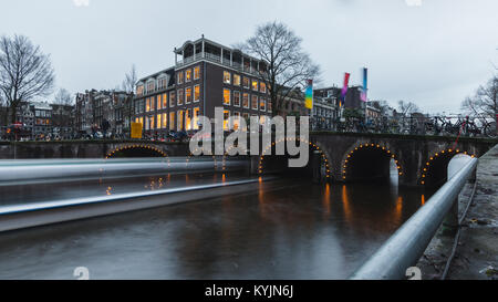 En passant par la croisière sous un pont-canal à Amsterdam pendant le crépuscule Banque D'Images