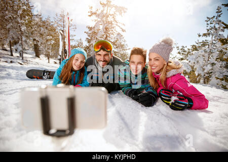 Happy Family enjoying les vacances d'hiver dans les montagnes et faire selfies Banque D'Images