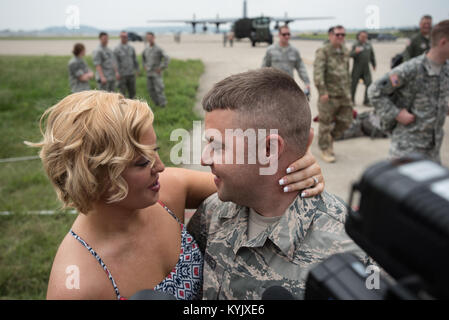 Tech. Le Sgt. Mike Johnson, chef de l'équipe d'un C-130 à la 123e Escadre de transport aérien, propose à son amie, Vanna Jones, sur la ligne de vol de la base de la Garde nationale aérienne du Kentucky à Louisville, Ky., 4 juillet 2015, après son retour d'un déploiement dans la région du golfe Persique. Jones a dit oui. (U.S. Photo de la Garde nationale aérienne par le Major Dale Greer) Banque D'Images