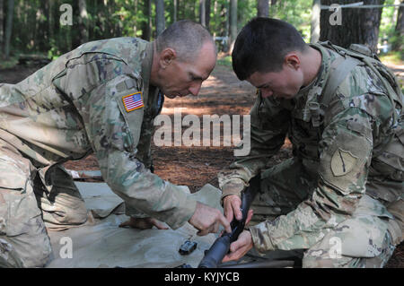 Le Sgt. David McDaniel, un fantassin attaché au 1er bataillon du 149e Régiment d'infanterie, inspecte un Mossberg 500 fusil tactique comme le Sgt. 1st. L'argile, une classe Dalton sergent du peloton affecté au 116e Brigadge d'infanterie, l'équipe de combat de la Garde nationale de la Virginie, de montres dans le cadre de l'essai pour le Badge d'infanterie d'experts le 5 août par le 10 août à Fort Pickett (VA), 254 soldats de la Garde nationale de la Virginie, Kyng's 116e Brigade Combat Team, 82e Division aéroportée, et l'armée britannique Princess of Wales's Royal Regiment ont pris part à la BEI, avec seulement 33 remplissant tous les tests avec succès. (U.S. N de l'armée Banque D'Images