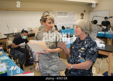 L'arrière de l'US Navy Adm. Priscilla Coe (à droite), chef d'état-major adjoint pour le Bureau de la marine américaine de médecine et de chirurgie et chef adjoint de la Réserve Marine Corps dentaire, parle avec l'U.S. Air Force aviateur Senior Kristin Bentley, un assistant dentaire de l'Utah Air National Guard's 151e Medical Group, sur les soins dentaires fournis aux patients à Paducah Tilghman High School de Paducah, Ky., le 23 juillet 2016, dans le cadre de Bluegrass Medical Innovative Formations de préparation. Le California Air National Guard, la réserve de la Marine américaine et d'autres unités militaires s'associent avec l'Autorité régionale d'offrir Delta Banque D'Images