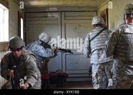 Le Sgt. 1re classe Josh Wilson (à gauche), Sgt. 1re classe James Elliott, Sergent d'Atanovich Josh et le capitaine Darren Kinman, effacer un bâtiment en zone urbaine 10 Août à Wendell H. Ford Centre de formation régional. Banque D'Images