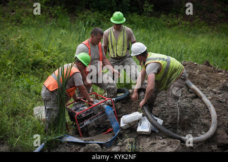 Aviateurs du Kentucky Air National Guard's 123e Escadron de génie civil utilisent une pompe à eau à jeter dans un nouveau tuyau d'extinction des incendies creusés étang au Camp William Hinds, un boy-scout camp à Raymond, Maine, le 23 juin 2017. La mission, une préparation à l'effort de formation novatrices qui consistait à rénover les installations du camp, le travail fourni gratuitement pour la communauté tout en doublant comme une précieuse expérience pour la formation des militaires de la Garde nationale de l'air, de la Réserve aérienne et Marine Corps Reserve. (U.S. Photo de la Garde nationale aérienne par le sergent. Joshua Horton) Banque D'Images