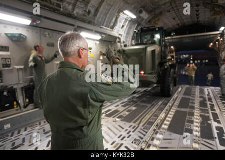 D'un arrimeur Virginia Air Guard guides un chariot élévateur de la Kentucky Air Guard's 123e groupe le Plan d'intervention sur un aéronef C-17 à la base de la Garde nationale aérienne du Kentucky à Louisville, Ky., le 29 août 2017 en prévision de l'ouragan Harvey de sauvetage dans le Texas. Plus de 40 aviateurs de l'Ohio et du Mississippi Air National Guard se déploient à l'Aéroport Intercontinental George Bush de Houston, où ils seront rapidement établir d'aviation, les opérations de chargement et d'évacuation aéromédicale. (U.S. Air National Guard photo par le Sgt. Phil Speck) Banque D'Images