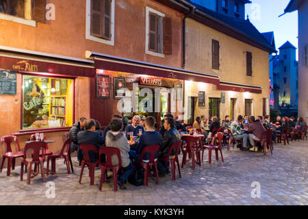 Les gens s'assoient autour de tables d'extérieur en face de la Café des Arts à Annecy, France Banque D'Images