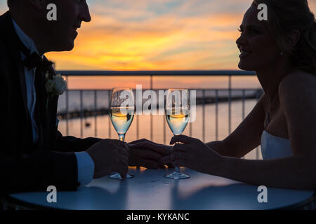 Des verres à vin sur balcon donnant sur St Kilda pier at sunset Banque D'Images