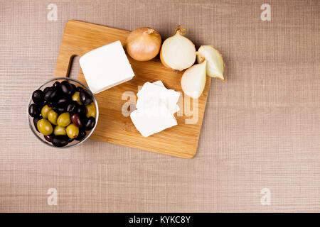 Le fromage Feta sur un sol en bois baord suivant pour couper les oignons Banque D'Images