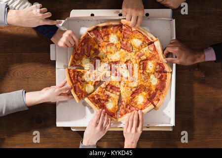 Groupe de mains en tenant chaque tranche de pizza à partir de la boîte Banque D'Images