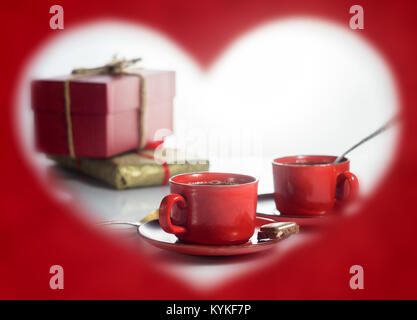 Le jour de la Saint-Valentin. Photo sous forme de coeur. Rouge deux tasses de café et des cadeaux Banque D'Images