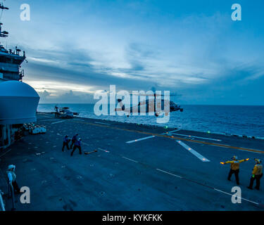 Mer des Caraïbes (oct. 03, 2017) le signal des marins l'atterrissage d'un MH-60S Sea Hawk comme le navire d'assaut amphibie USS Wasp LHD (1) le transit de la mer des Caraïbes à l'appui des efforts de secours à Porto Rico. Le Wasp est d'aider aux secours après le passage de l'Ouragan Maria. Le ministère de la Défense soutient l'Agence fédérale de gestion des urgences, le principal organisme fédéral, en aidant les personnes touchées par l'Ouragan Maria afin de minimiser la souffrance et est une composante de l'ensemble de l'intervention. (U.S. Photo par marine Spécialiste de la communication de masse 2e classe Rawad Mad Banque D'Images