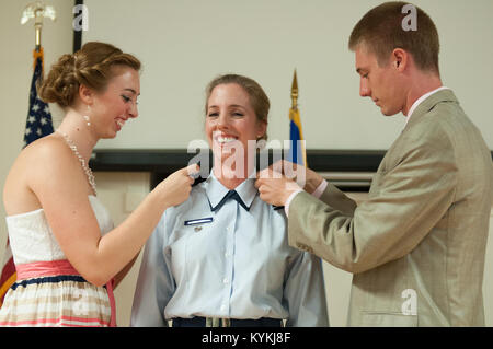 Les enfants du colonel Kathryn Pfeifer broche insigne de grade du colonel à son chemisier uniforme au cours d'une cérémonie à la promotion de la base de la Garde nationale aérienne du Kentucky à Louisville, Ky., 17 août 2013. Pfeifer, directeur de cabinet de l'Administration centrale, Kentucky Air National Guard, est la première ligne féminine commissariat pour atteindre le grade de colonel dans la garde de l'air du Kentucky. (U.S. Photo de la Garde nationale aérienne Aviateur Senior Vicky Spesard) Banque D'Images