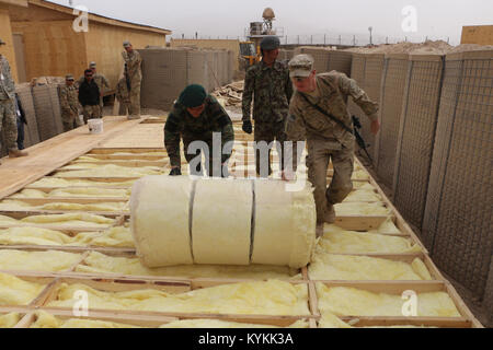 La CPS. Clyde Porter avec la 149e compagnie de construction verticale ainsi que deux soldats de l'Armée nationale afghane de terminer l'installation d'isolation du plancher sur un site de construction sur base d'éclairs, à Gardez, Afghanistan. (U.S. Photo de la Garde nationale par la CPS. Jean Rader) Banque D'Images