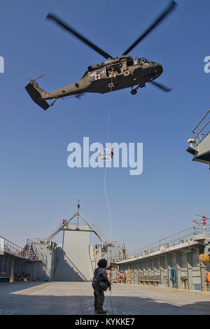 "UH-60 Black Hawk" des hélicoptères de la compagnie C du 2e Bataillon, 238e bataillon de l'aviation d'appui général procède à la formation de renvoi au large des côtes du Koweït dans le golfe Arabo-Persique. La formation spécialisée prépare les équipes d'évacuation sanitaire d'extraire des aviateurs tombés en mer. Le 2-238e comprend des soldats de l'Indiana et Kentucky Army National Guard et est actuellement déployée au Moyen-Orient avec la 36e Brigade d'aviation de combat (Texas Army National Guard) à l'appui de l'opération Enduring Freedom. (U.S. Photo de l'armée par le Sgt. Mark Scovell/libérés) Banque D'Images