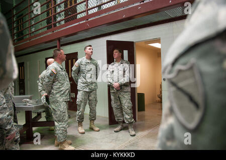 Air Force, le général Edward Tonini, adjudant général de l'état du Kentucky, est informé de l'utilisation des parties communes, par armée 1 Le lieutenant Joseph Smith, le sous-officier responsable du camp V, à l'intérieur de Camp V à la station navale des États-Unis à Guantanamo Bay, Cuba le 3 décembre 2013. Tonini est venu à l'île à visiter avec des gardes du Kentucky déployés à GTMO à l'appui d'opérations d'affaires publiques. Army National Guard (photo par le Sgt. David Bolton/Mobile 133e Détachement des affaires publiques/Groupe de travail conjoint-GTMO Affaires publiques) Banque D'Images
