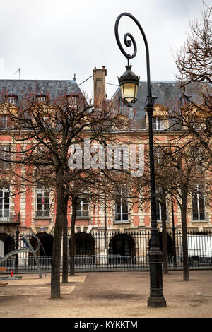 Place des Vosges Paris belle place, la plus ancienne de la ville. Spirale ornés lampadaire en premier plan. Scène d'hiver Banque D'Images
